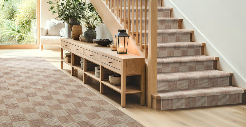 Home interior scene with staircase and beige checkered rug runner