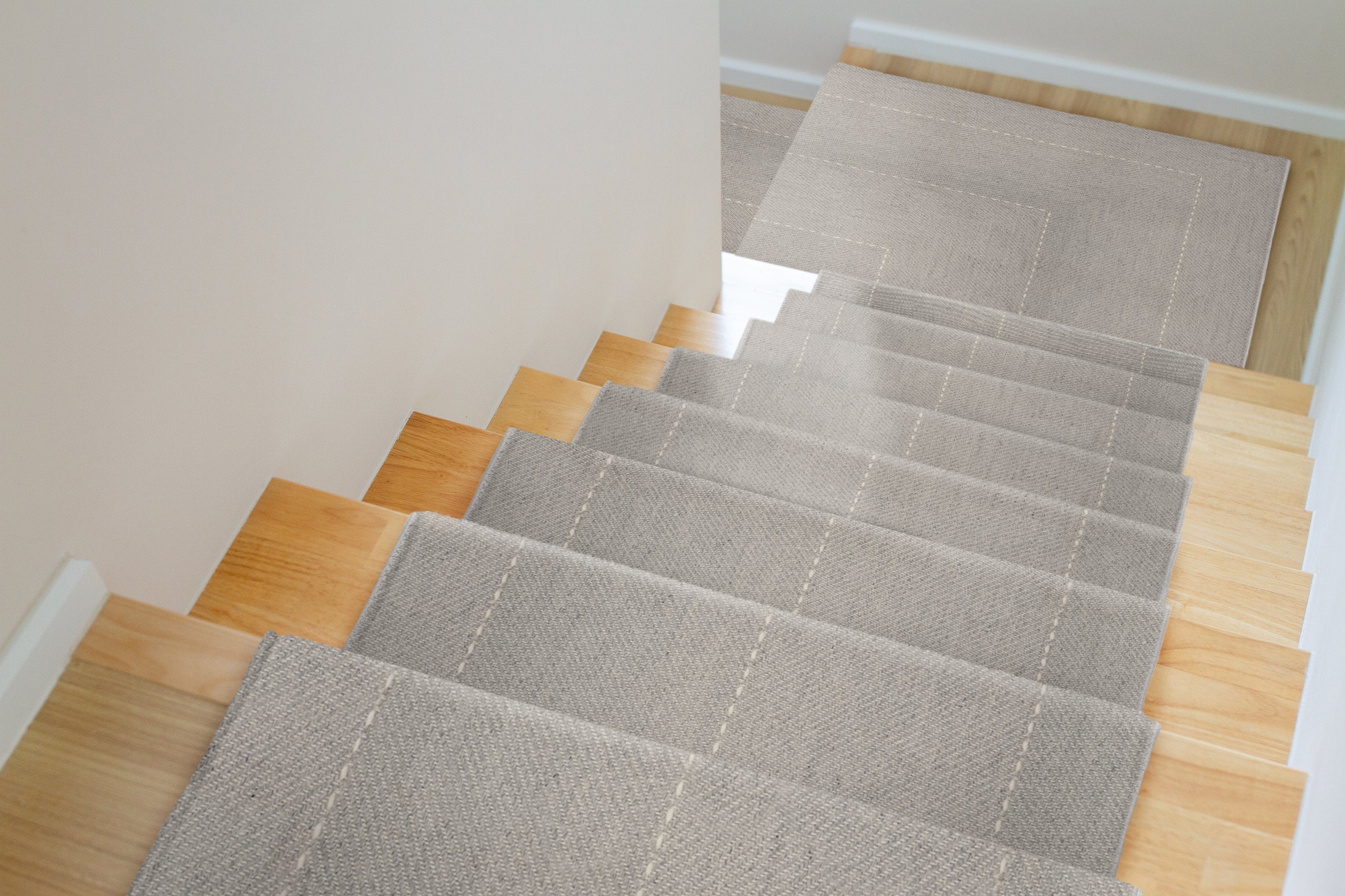 Gray stair runner rug on wooden stairs in a home interior