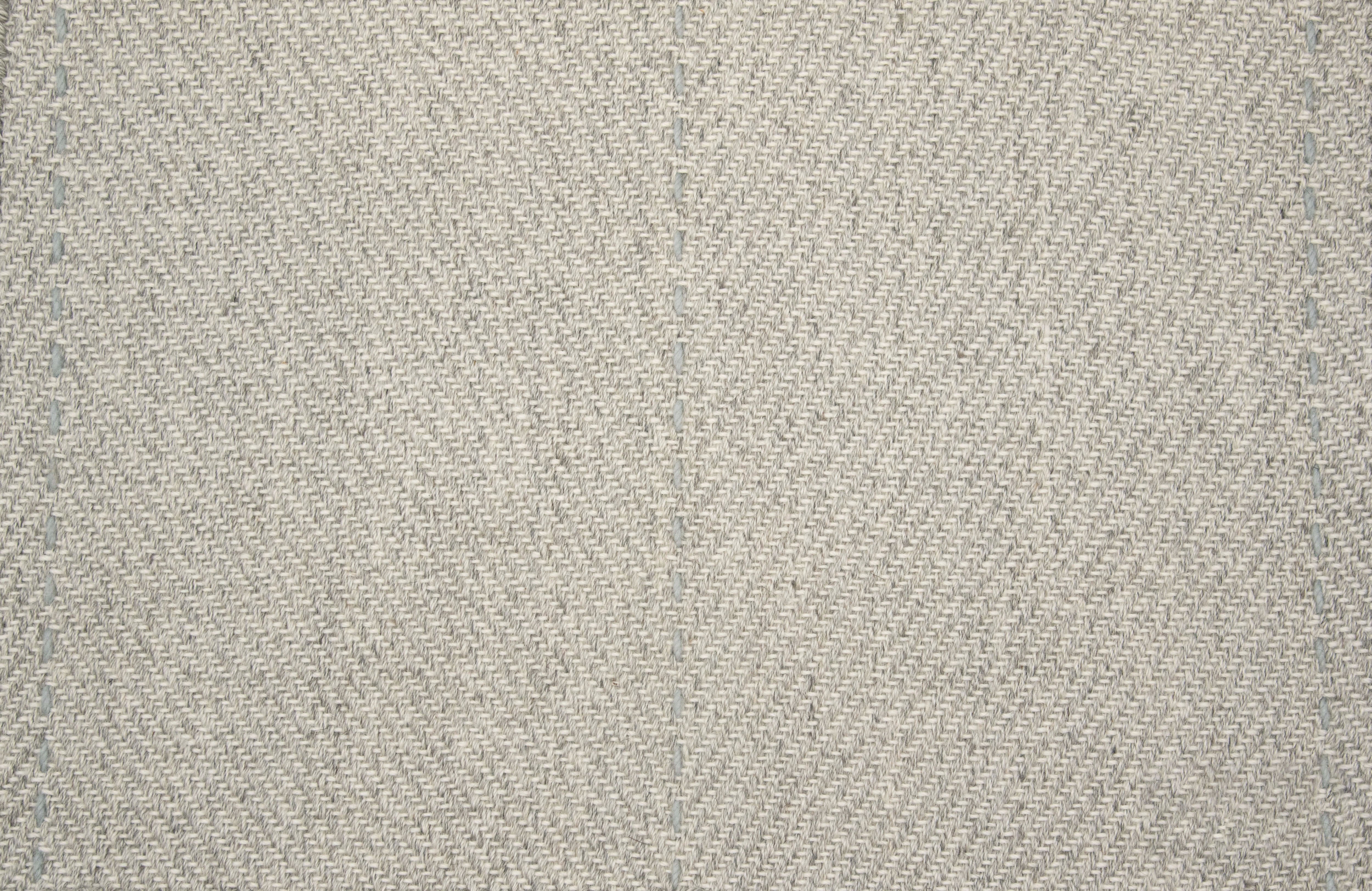 Textured gray fabric rug pattern with subtle woven design