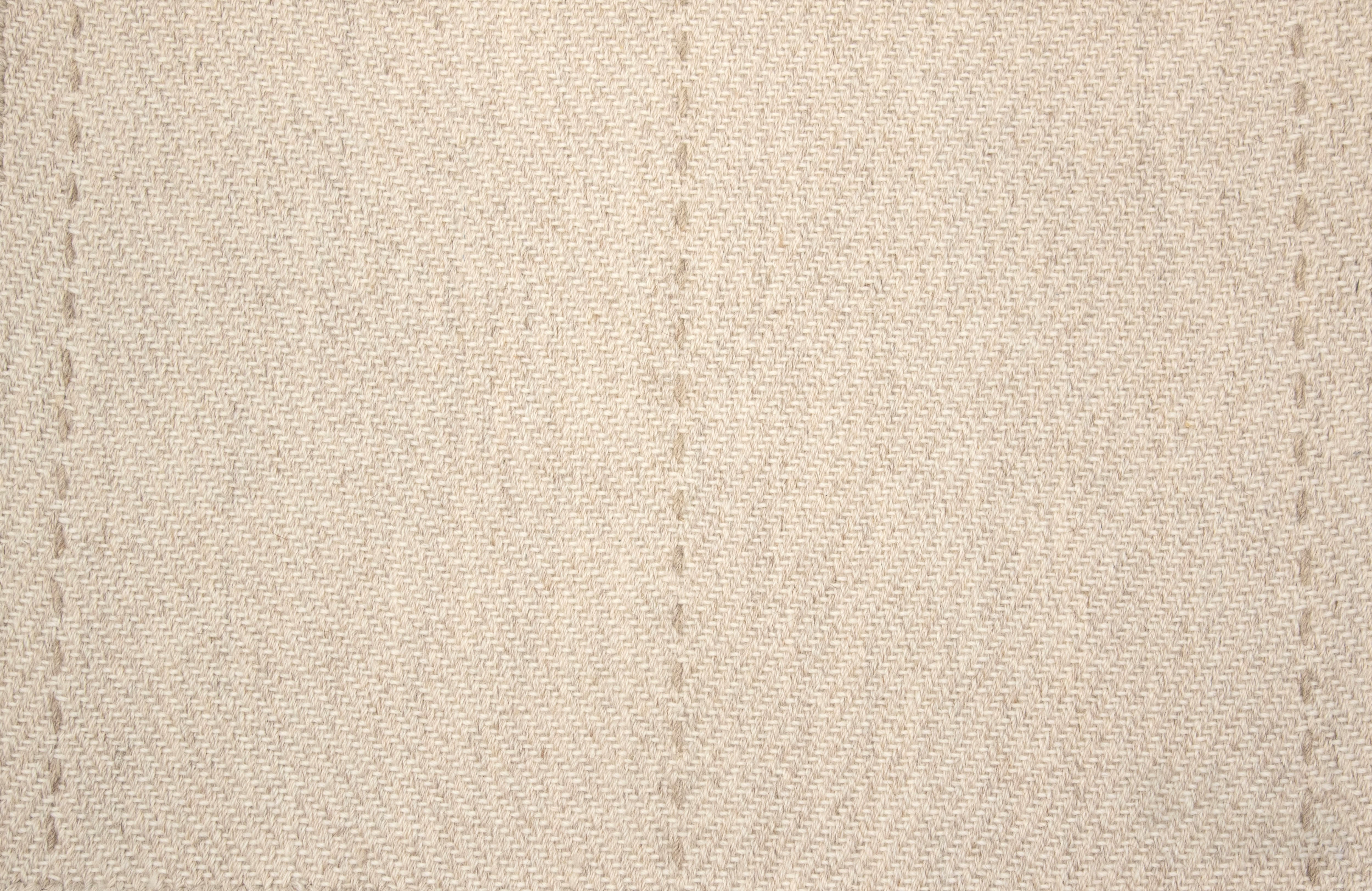 Beige fabric rug with subtle stitched pattern
