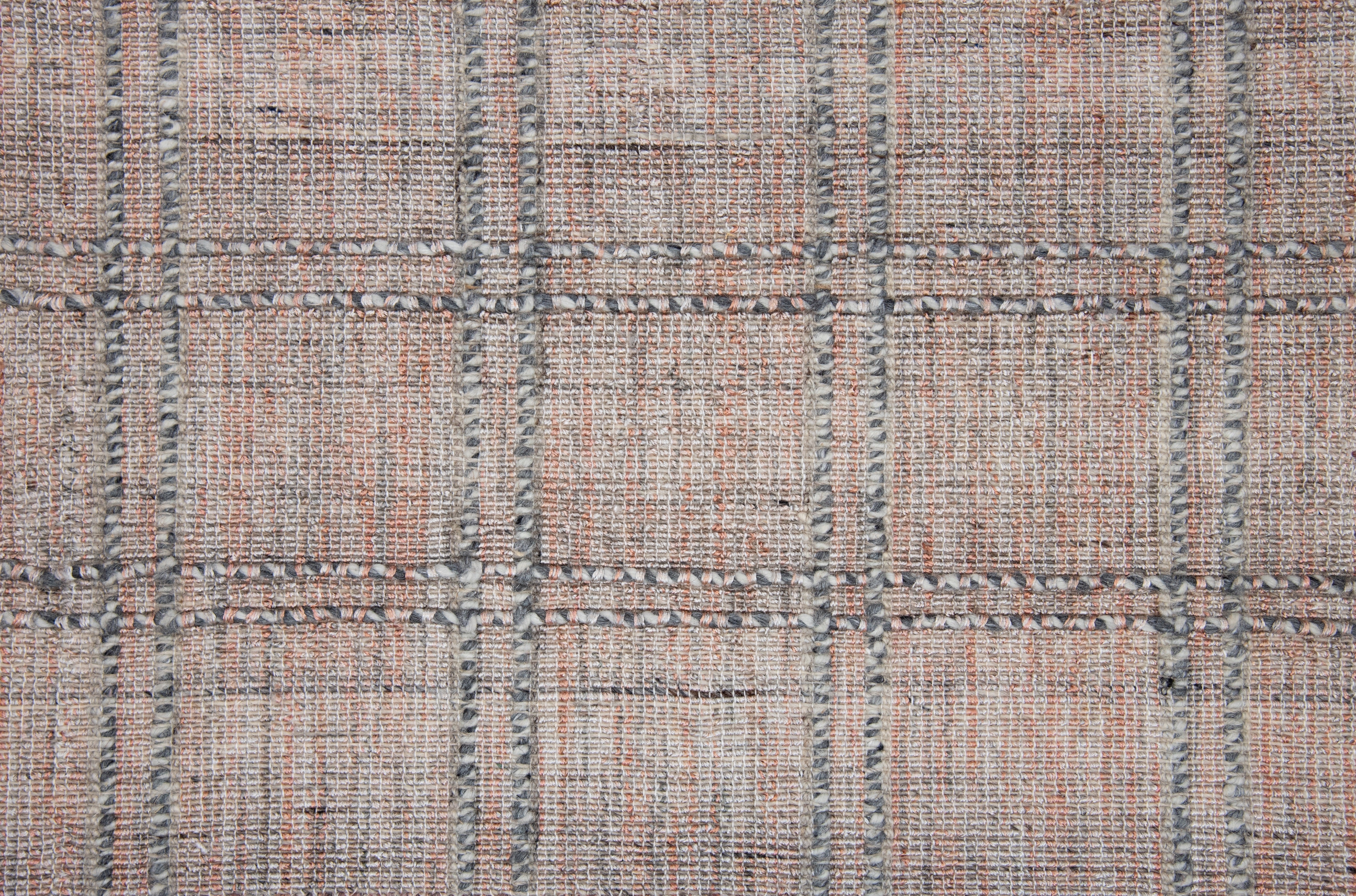 Textured tweed rug in rose and gray tones with checkered pattern